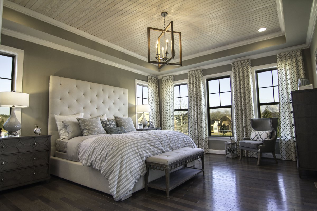 The owner's suite in this Crawford plan features hardwood floor and wood tray ceiling.